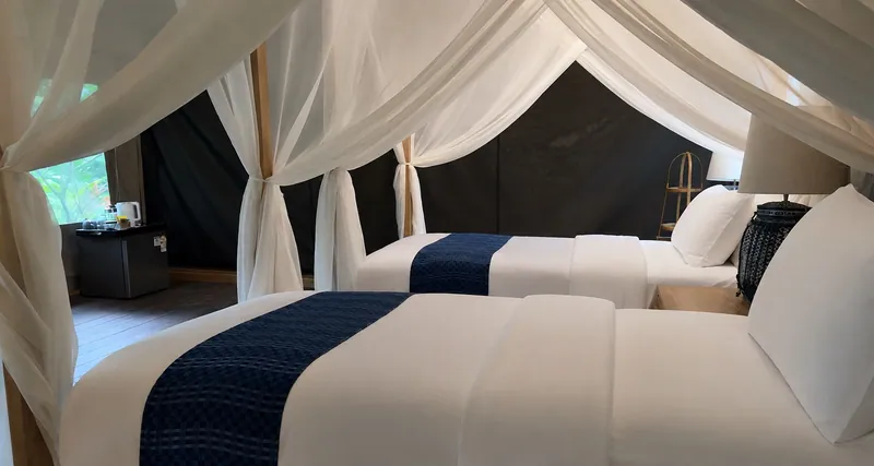 Khun Nan tent interior with twin beds and indigo cushions